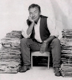 Will sits among stacks of Newspapers